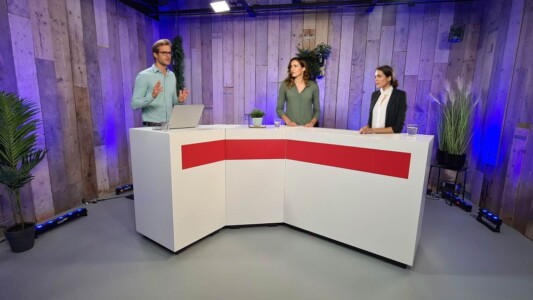 Een opstelling voor een webinar met een panelgesprek met 3 experts.